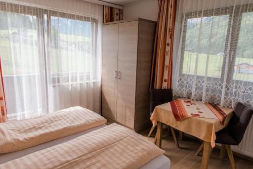 1 dormitorio con 2 camas, mesa y ventana en Unterwötzlhof, en Abtenau