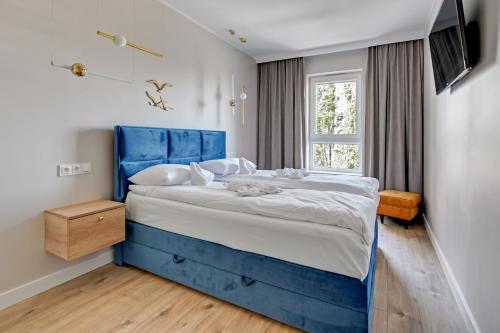 a blue bed in a room with a window at Wave Apartments - Mezzo in Gdańsk