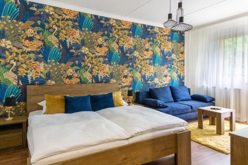 sypialnia z łóżkiem i niebieską kanapą w obiekcie Secret Garden Apartman w Miszkolcu