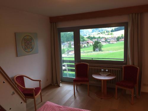 a room with a table and chairs and a large window at Gästehaus Schröder in Ruhpolding