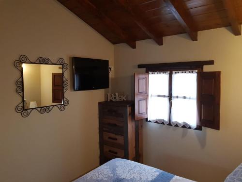 una camera da letto con specchio, cassettiera e finestra di El Navariegu 2 a Villanueva de Pría