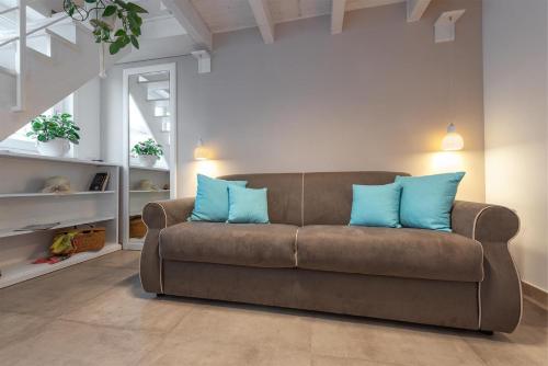 salon z brązową kanapą z niebieskimi poduszkami w obiekcie B&B Il Cortiletto w mieście Porto Cesareo