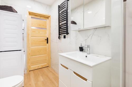 a white bathroom with a sink and a toilet at Bm apartamenty Wały Chrobrego Radogoska12A in Szczecin