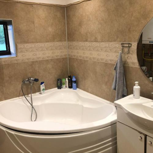 a bathroom with a white tub and a sink at Guest House Maja in Novi Sad