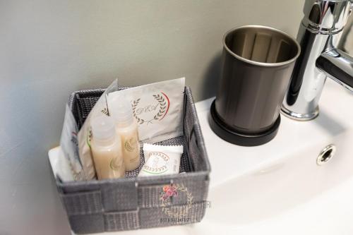 a basket on a sink with soap and a cup at Duchessa Ravaschieri bed and breakfast in Naples