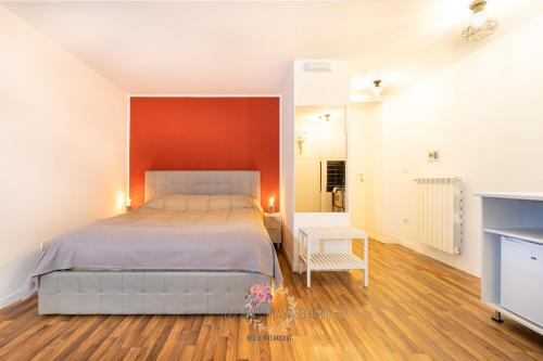 a bedroom with a bed and a red wall at Duchessa Ravaschieri bed and breakfast in Naples