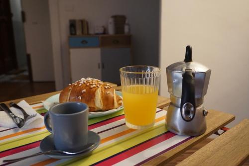a table with a plate of bread and a glass of orange juice at Duchessa Ravaschieri bed and breakfast in Naples