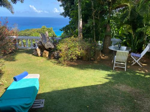 a backyard with a table and chairs and the ocean at Casa Doro Villa in Glacis