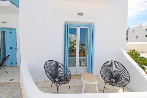 two chairs and a table on a balcony with a building at Harmony Boutique Hotel in Mýkonos City