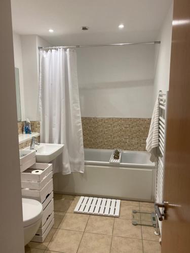 a bathroom with a tub and a toilet and a sink at Riverside Townhouse, Only 20 Minutes from Brighton and Worthing in Shoreham-by-Sea