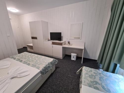 a room with two beds and a desk and a mirror at Villa Yanevi in Ravda