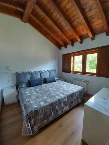 1 dormitorio con 1 cama en una habitación con techos de madera en El Cuadron en Camango