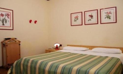 シラクーサにあるResidence Royalのベッドルーム1室(緑と白のストライプの毛布付きのベッド1台付)