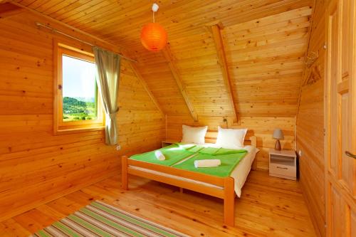 a bedroom with a bed in a log cabin at Family lux Apartments in Žabljak