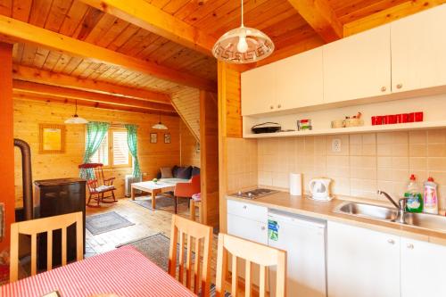 a kitchen and living room in a log cabin at Family lux Apartments in Žabljak