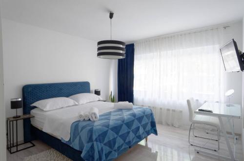 um quarto com uma cama azul e branca e uma secretária em Maximus em Čakovec