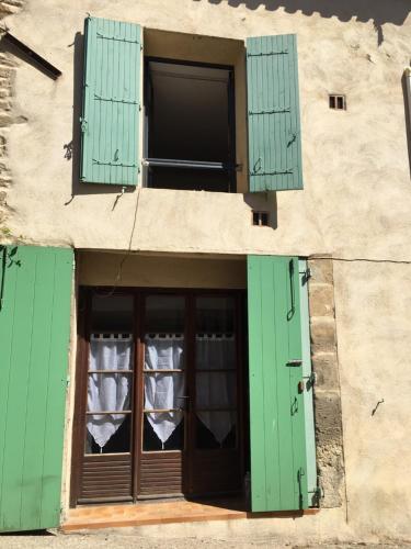 una ventana abierta con persianas verdes en un edificio en The Old Barn, en La Tour-dʼAigues
