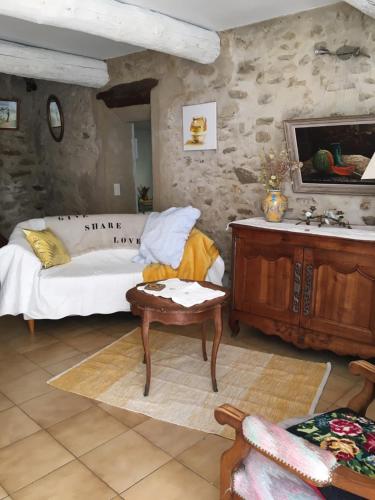 Sala de estar con cama y mesa en The Old Barn, en La Tour-dʼAigues