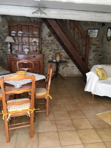 un comedor con mesa y sillas y una escalera en The Old Barn, en La Tour-dʼAigues