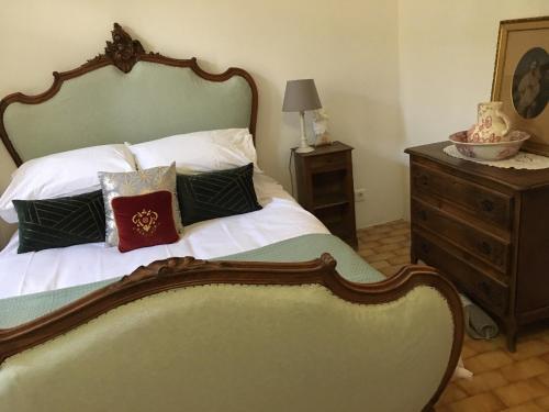 1 dormitorio con 1 cama con cabecero de madera y vestidor en The Old Barn, en La Tour-dʼAigues