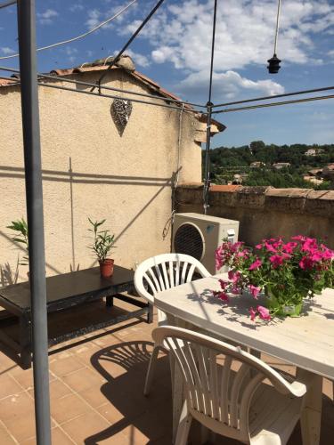 un patio con mesa, sillas y flores en The Old Barn, en La Tour-dʼAigues