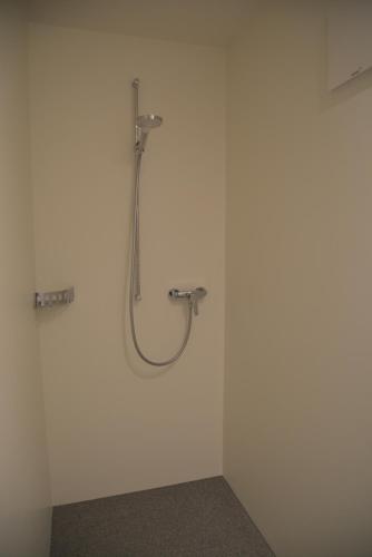 a bathroom with a shower in a white wall at Ferienwohnung Grunholz in Andelsbuch