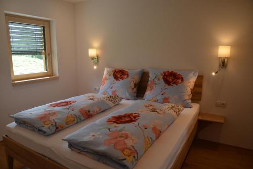a bedroom with two beds with flowers on them at Ferienwohnung Grunholz in Andelsbuch