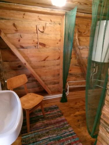 a bathroom with a toilet and a chair in a room at Kadariku Tourism Farm in Sakla