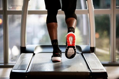a person wearing orange and black shoes on a treadmill at Park Hyatt Toronto in Toronto