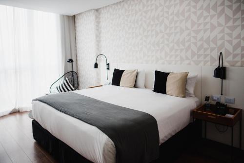 a bedroom with a large white bed and a window at CasaSur Palermo Hotel in Buenos Aires
