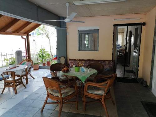 a dining room with a table and chairs at APARTMENTS HARIS in Olympiaki Akti
