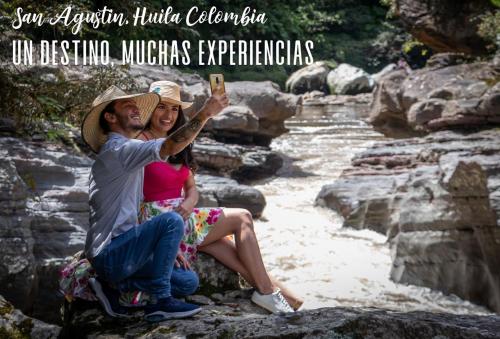 a man and a woman taking a picture of a river at Hotel Alto de los Andaquies in San Agustín