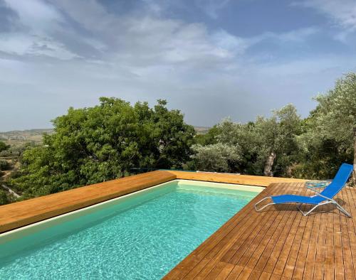 eine Terrasse mit einem Pool und einem blauen Stuhl in der Unterkunft Villa Ananda homestay & yoga retreat in Palazzolo Acreide