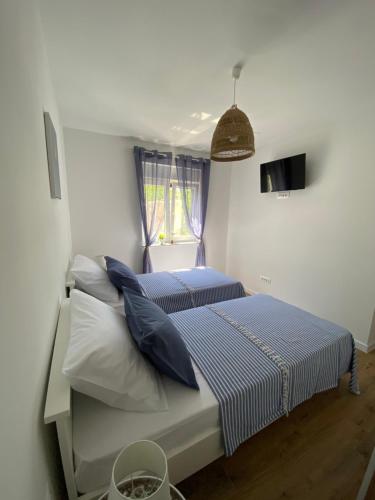a bedroom with two beds with blue and white pillows at Holiday house Aria di Mare in Starigrad-Paklenica
