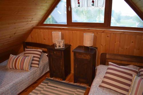 a room with two beds and a window in a cabin at Ogród Shinrin Yoku Odpoczynek w Lesie in Srokowo