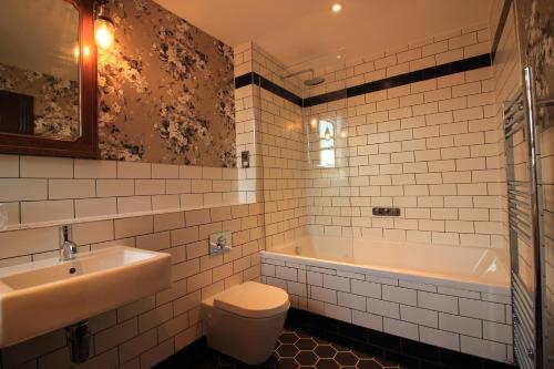 uma casa de banho com um lavatório, uma banheira e um WC. em Westow House em Crystal Palace
