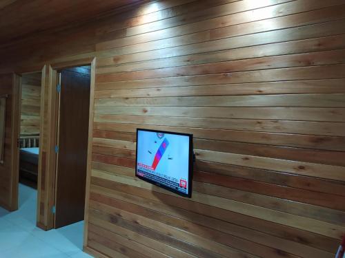 a television on a wooden wall in a room at Pousada Flor do Campestre in Urubici