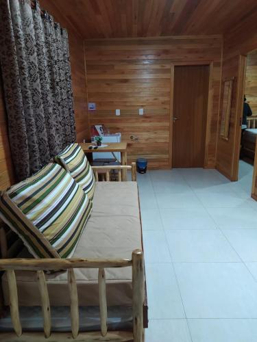 a room with a rocking chair and a table at Pousada Flor do Campestre in Urubici