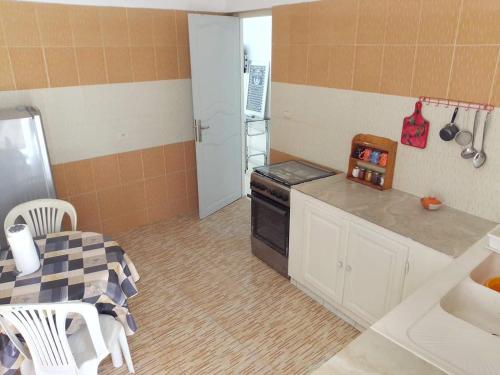 een keuken met een fornuis en een tafel erin bij S+2 Beltaief Residence in Houmt Souk