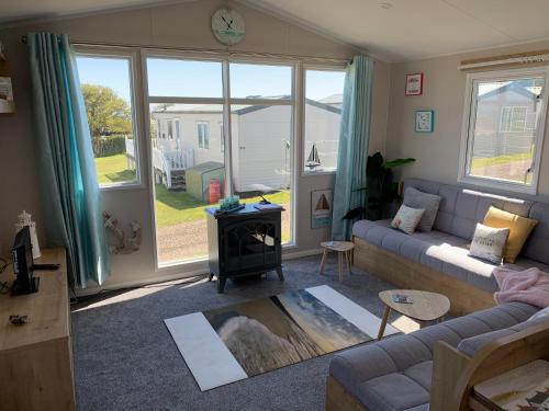 a living room with a couch and a stove at Bliss Beach Lodge Breath taking views in Bembridge