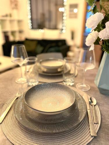 une table avec une assiette, des fourchettes et des verres dans l'établissement Petit cocon au cœur d'Annecy, à Annecy