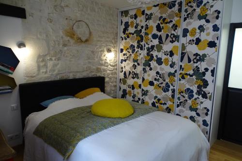 - une chambre avec un lit doté d'un oreiller jaune dans l'établissement Le Saint-Claude, Appt au coeur de ville, à La Rochelle