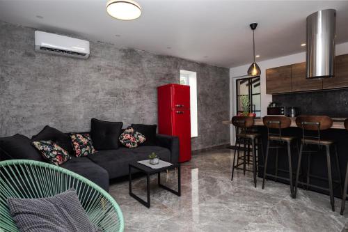 a living room with a black couch and a red refrigerator at Luxury Apartman Tinel in Mimice