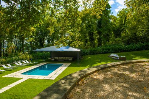 um quintal com uma piscina e um gazebo em Le Château d Hardricourt em Hardricourt