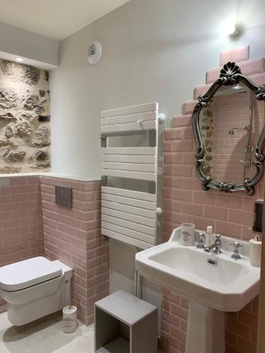 a pink bathroom with a sink and a toilet at Achilée Les Herbes de la saint Jean in Saint-Bonnet-le-Froid