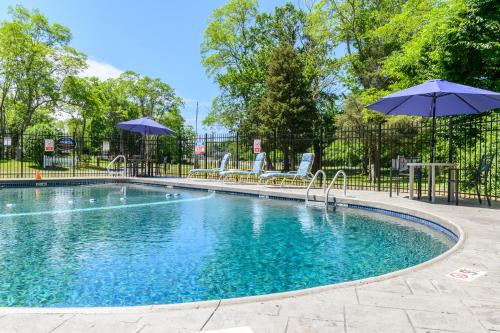a pool with umbrellas in the middle of it at Captains Quarters Motel & Conference Center in Eastham