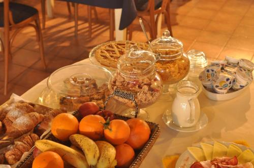 un tavolo con un mucchio di frutta e altri alimenti di Hotel Borgo Antico a Bibbiena