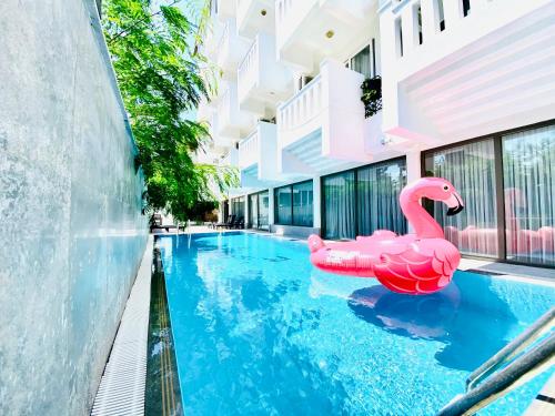 una piscina con un flamenco rosa en el agua en Royal City Hotel, en Antalya