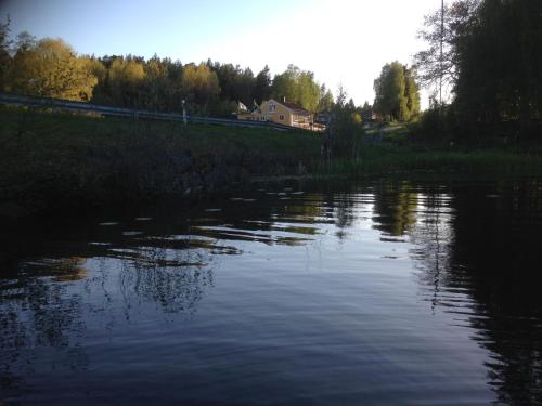 a large body of water with a house in the background at Motel E4 Kolmården Apartments And Cottages in Kolmården