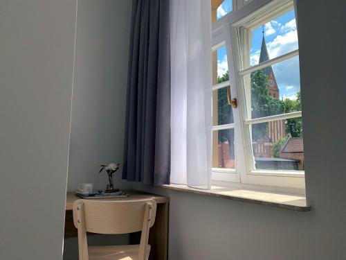 a chair sitting in front of a window at DOMUS MARIAE Gietrzwałd in Gietrzwałd